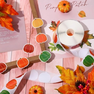 Detail of autumn pumpkin stickers roll with gold foil edges and festive maple leaf decor