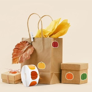 Detail of colorful pumpkin stickers applied to kraft gift bags and holiday boxes
