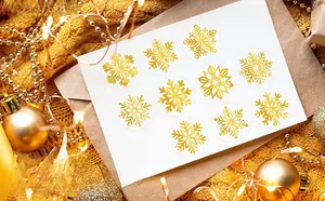 Close-up of gold foil snowflake stickers on an envelope with festive holiday decor