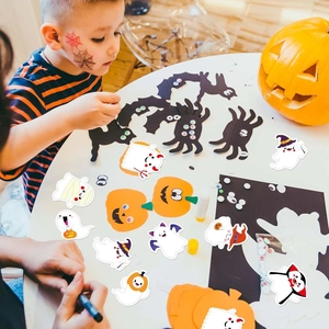 Close-up of children DIY crafting with cartoon ghost and pumpkin Halloween stickers