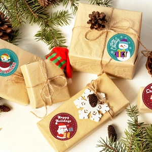 500 Christmas stickers featuring snowmen and Santa on kraft gift boxes with festive pine decor
