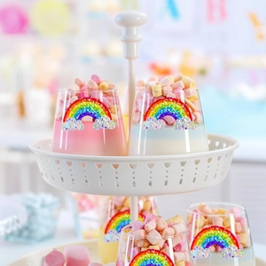 Rainbow laser cloud stickers applied to a decorative glass dessert cup on a tiered stand