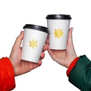 Christmas paper cups with gold snowflake stickers and black lids for winter holiday party