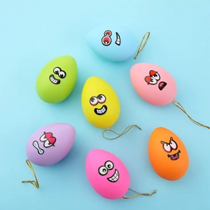 Detail showing 7 colorful egg pendants with funny faces and gold hanging strings
