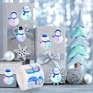 Roll of holographic Christmas snowman stickers on silver gift boxes for holiday decor