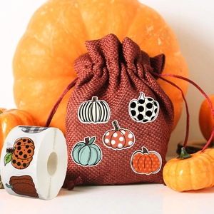 Roll of 500 rustic autumn pumpkin stickers applied on burlap bag for fall festive decor