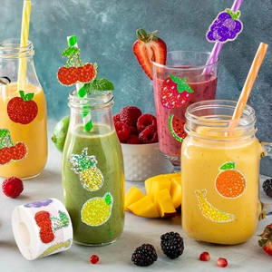 Close-up of glittery fruit stickers on mason jars featuring cherry and lemon designs