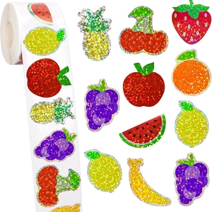 Roll of glittery summer fruit stickers with strawberry and lemon designs on white background