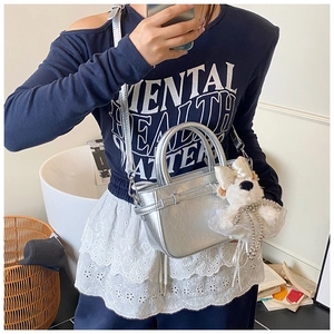 Sac à main argenté avec pendentif chien en peluche blanc et chaîne de perles élégante