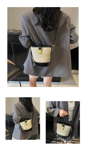 Close-up of beige canvas and black leather bucket bag with gold metal buckle and lettering