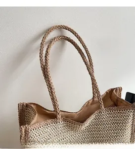 Detail of sturdy double-woven handles and secure zipper closure on straw tote bag