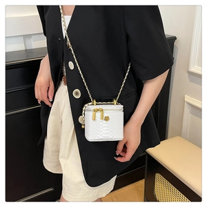 Detail view of white snakeskin texture mini bag with gold chain and flower zipper charm