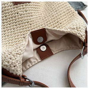 Detail view of woven knit bucket bag with brown leather trim and magnetic closure