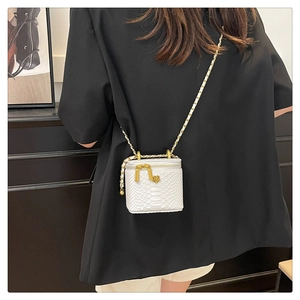 Detailed back view of a white snake-pattern mini crossbody bag with gold flower charm