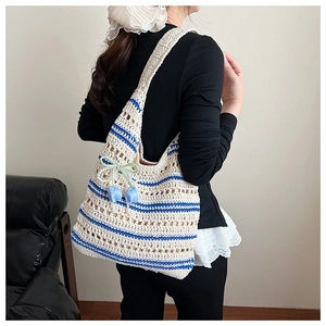 Detail of hand-woven cotton tote bag with blue stripes and decorative tulip pendant