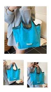 Detailed view of the bright blue casual foldable tote bag, featuring dark green trim and tag.