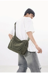 Detailed view of army green canvas messenger bag showing large capacity and flap closure