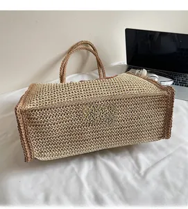 Detailed close-up of the dense weaving and sturdy base of this beige straw tote bag