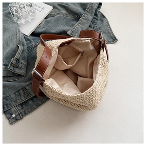 Close-up of woven straw tote bag with beige fabric lining and internal zipper pocket