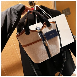 Dettaglio della borsa a secchiello in tela con finiture in pelle e patch Fashion