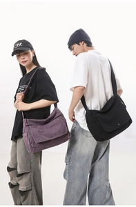 Detail of large capacity canvas messenger bag with flap cover and wide strap for comfort