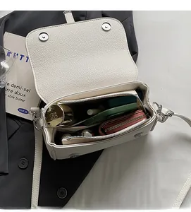 Interior view showing the storage capacity of the white textured leather crossbody bag