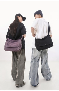 Detailed view of vintage washed canvas messenger bags in purple and black colors