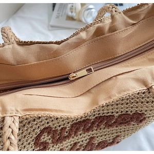 Close-up of metal zipper closure and fabric lining on Summer straw tote bag