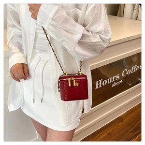 Detail of red snake pattern mini square bag with camellia zipper and chain strap