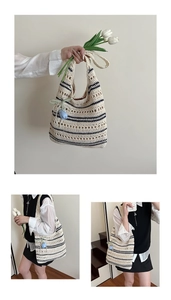 Detail of hand-woven hollow knit tote bag with black stripes and blue tulip charm