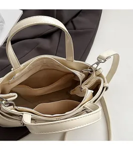 Dettaglio interno della borsa beige con scomparti con cerniera e spazio organizzato