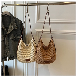 Detailed close-up of woven shoulder bags in beige and brown with leather straps