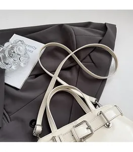 Vista dettagliata della borsa vintage crema con fibbie argentate e finitura lucida