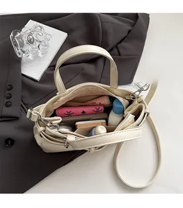 Dettaglio dell'ampio scomparto interno della borsa a mano beige con fibbia retrò