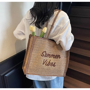 Detail of Summer Vibes embroidery on a woven straw tote bag with tulip decorations
