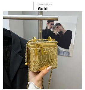 Detail view of the mini gold snakeskin texture chain bag with floral relief and dual zippers