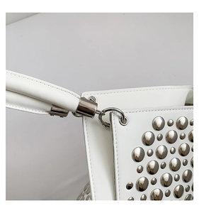 Gros plan détaillé d'un sac en cuir blanc avec clous argentés et crochet métallique