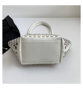 Détails des rivets argentés sur sac bandoulière blanc avec coutures de base renforcées