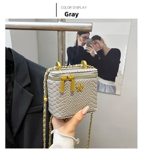 Detail of grey snakeskin embossed crossbody bag with gold floral zipper and chain strap