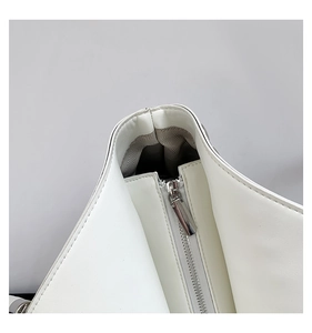 Détail de fermeture éclair argentée et doublure à chevrons sur sac en cuir blanc