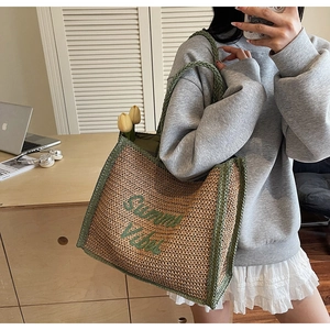 Fashionable straw shoulder bag with Summer Vibes embroidery shown in a lifestyle setting