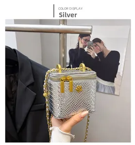 Detail of silver snake texture mini bag with gold camellia hardware and chain strap