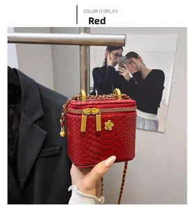 Detail of red snake pattern mini bag with gold flower hardware and chain strap