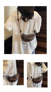 Detail of soft leather crescent bag with unique shoulder strap knot and smooth zipper