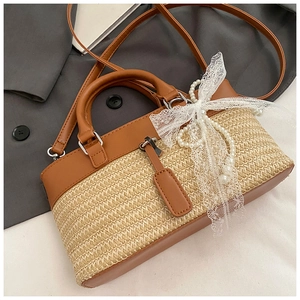 Detail of straw handbag featuring leather trim and white lace bow with pearl beads