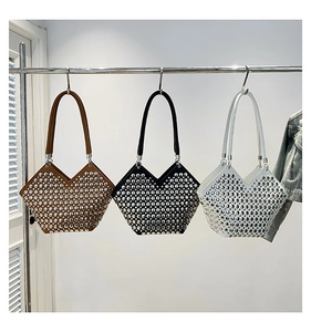 Trois sacs à bandoulière cloutés en marron noir et blanc suspendus sur un support