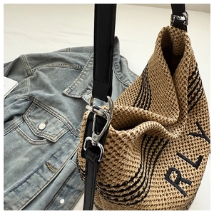 Close-up of beige woven bucket bag with black RLY embroidery and leather strap