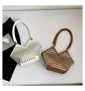 Détail de sacs fourre-tout blanc et caramel avec clous métalliques et coupe en V