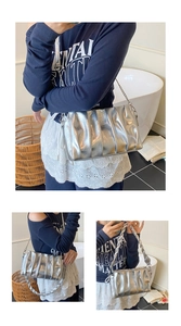 Detail of silver pleated crossbody bag with chain strap and chunky woven handle