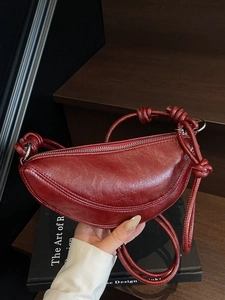 Vintage burgundy half-moon shoulder bag in textured faux leather with knotted strap details